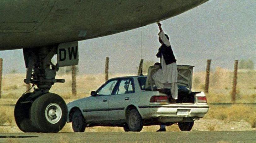 A Taliban security official receives a paper on which the hijackers of Indian Airlines flight IC-814 have put their demands at Khandahar airport, 27 December, 1999. The Muslim militant hijackers are demanding the release of Muslim cleric Moulana Masood Azhar jailed in Kashmir since 1994 by Indian authorities. AFP PHOTO Saeed KHAN (Photo by SAEED KHAN / AFP) (Photo by SAEED KHAN/AFP via Getty Images)