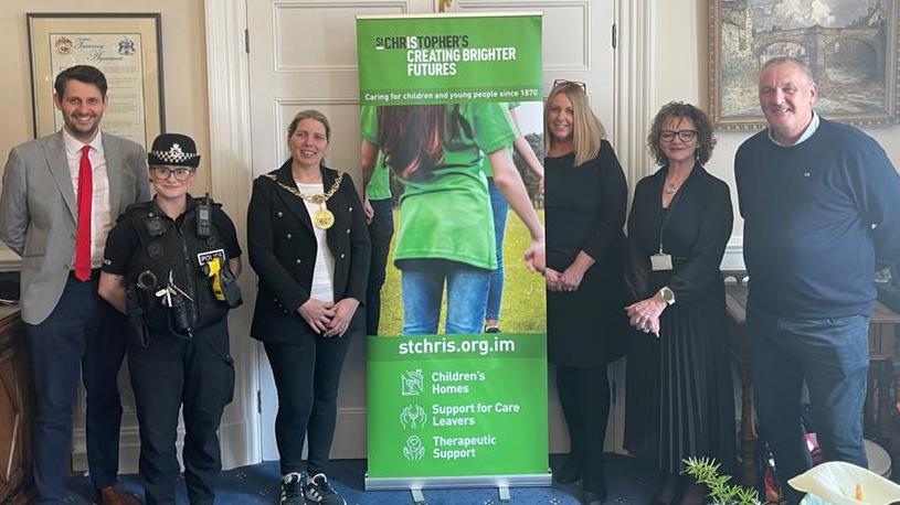 Six people from different professions smiling next to a streetwise banner