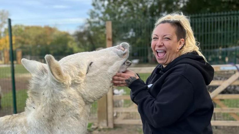 Jodie Marsh smiling at the camera while stroking one of the rescued animals in her farm 