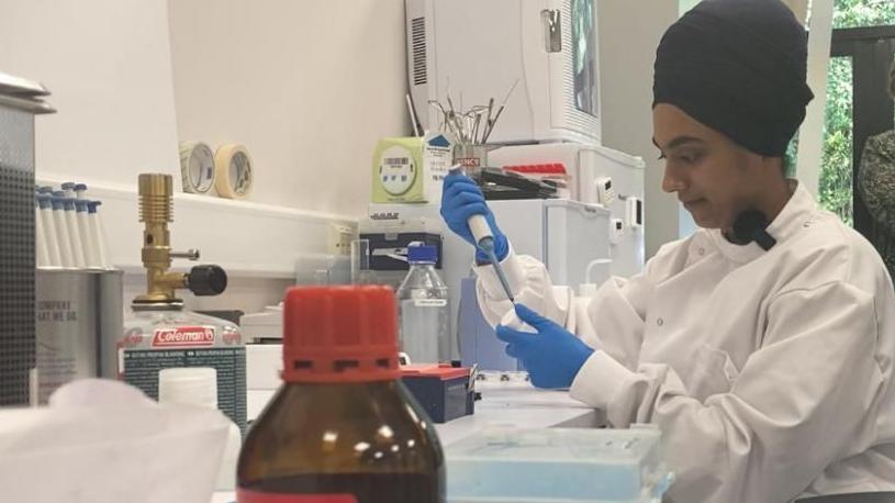 A view of a researcher preparing samples to be analysed in a machine.