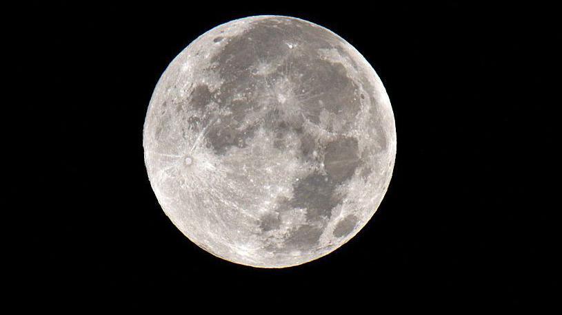 The full harvest Moon pictured on 7 October, a grey moon with light and dark patches in night sky