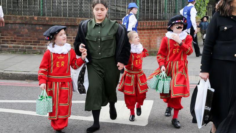 Jewish children dress up as traditional London Beefeater guards for a Purim festival in 2024. 