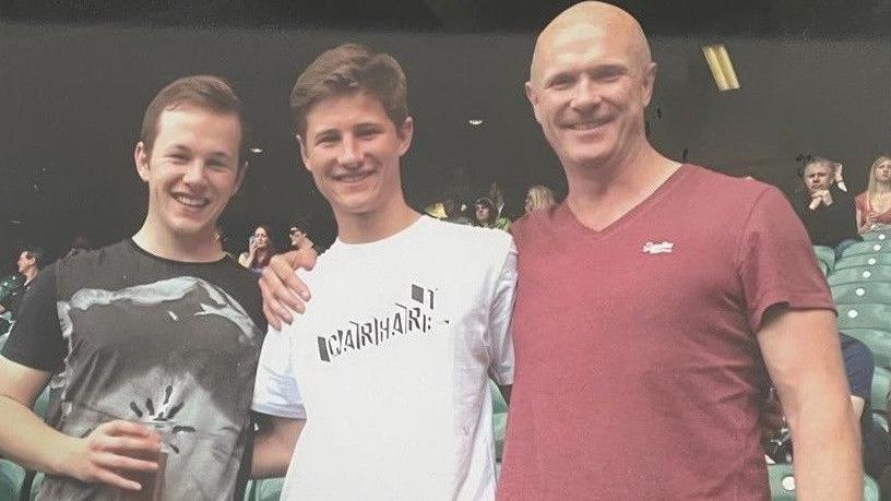 Brothers Euan and Fraser Dingwall stand alongside their father Gordon while watching the Premiership final at Twickenham in 2014