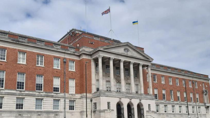 Picture of the red-brick Chesterfield Town Hall. A British and Ukrainian flag fly on two masts from the roof. 