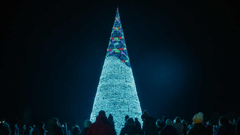 A christmas tree lit up by lanterns