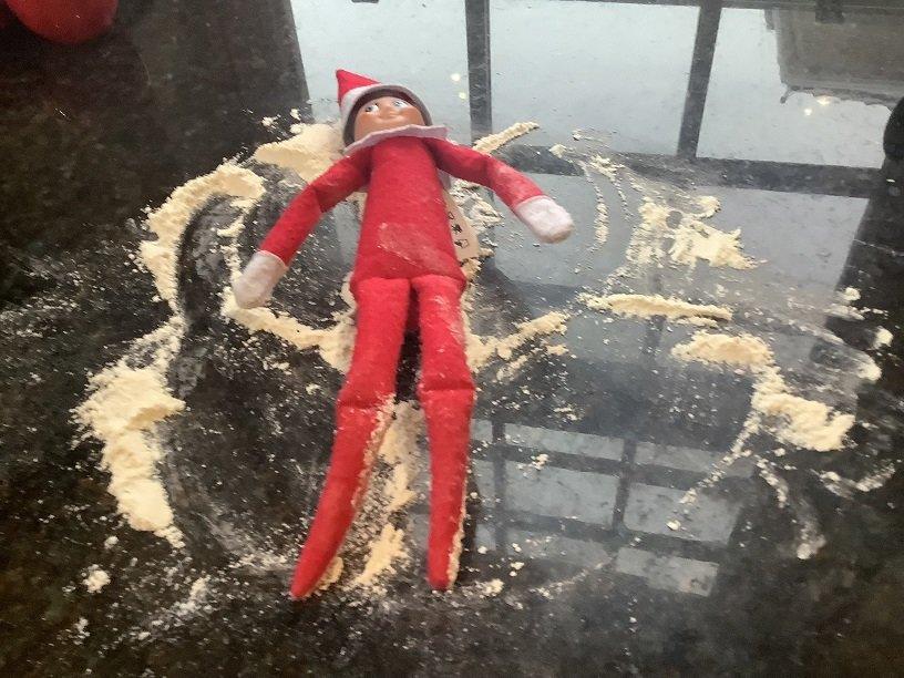 elf doing snow angels in some flour