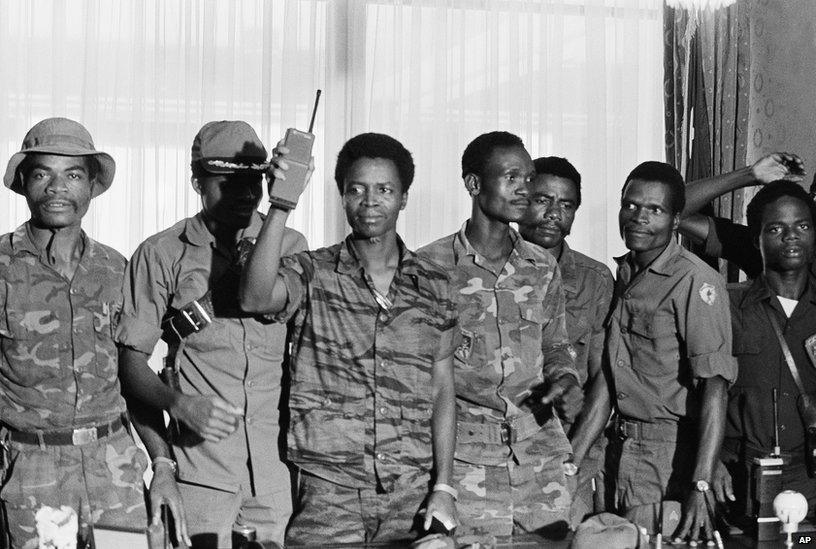 Master Sgt. Samuel K. Doe, Liberia new chief of state, flourished walkie-talkie radio, as he posed with members of the ruling "People's Redemption Council," shortly after the April 12, 1980 overthrow of President Willium R Tolbert Jr.