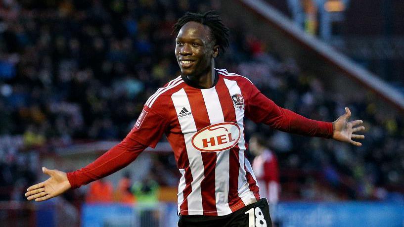 Vincent Harper holds his arms out at his sides in celebration at scoring for Exeter City