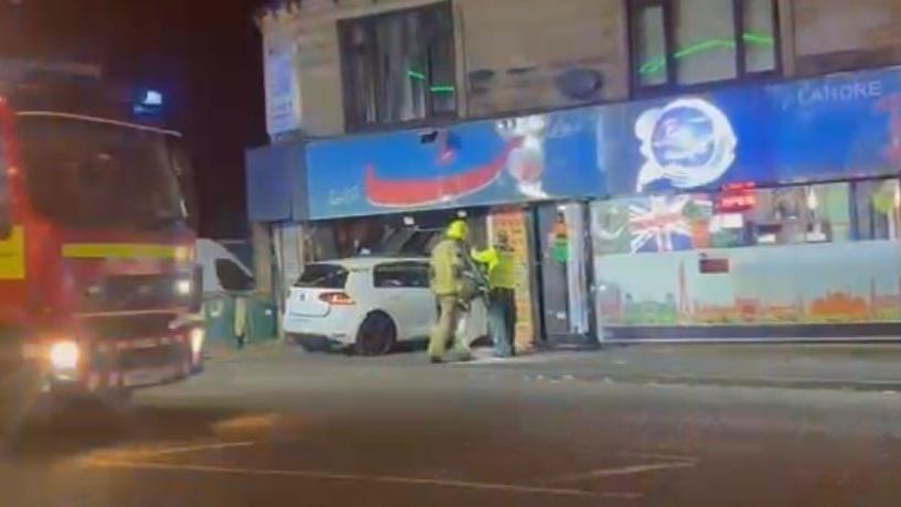 Emergency services examiner a car which has crashed into a restaurant