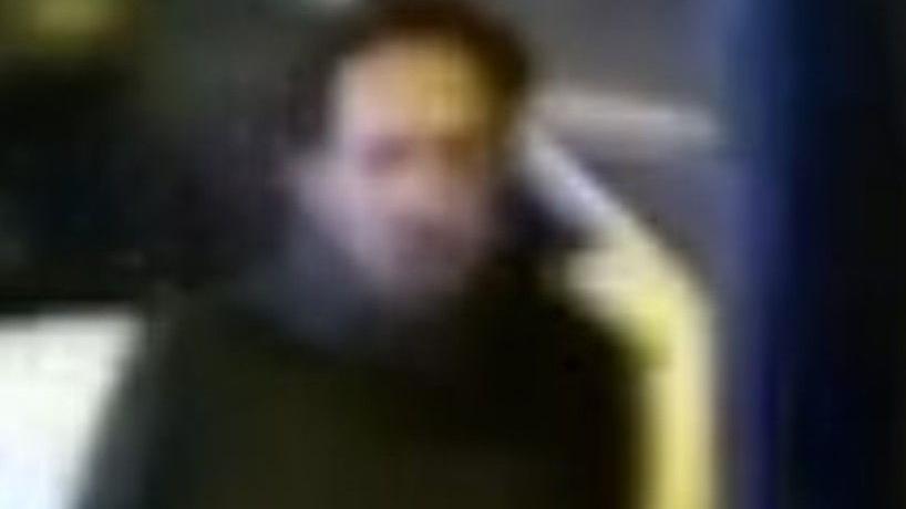 A CCTV image of a man police want to speak to. It is an unclear image which shows a man with dark hair wearing a dark coat. 