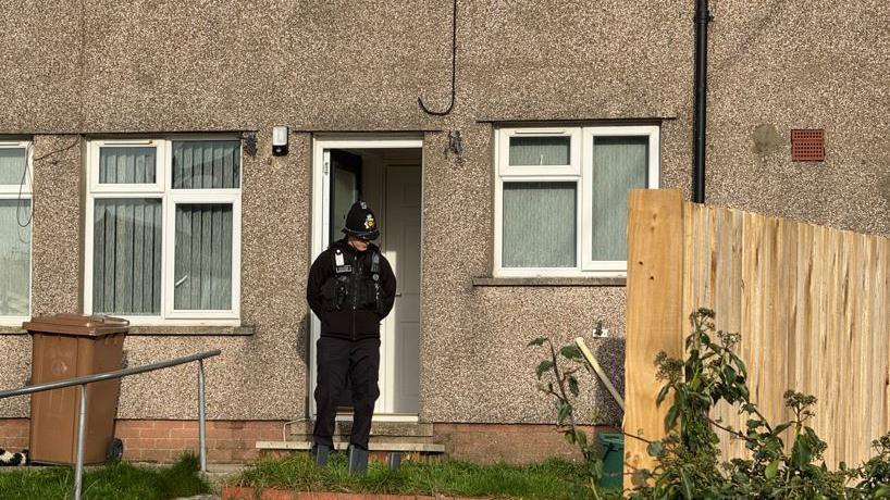 A policeman outside a property