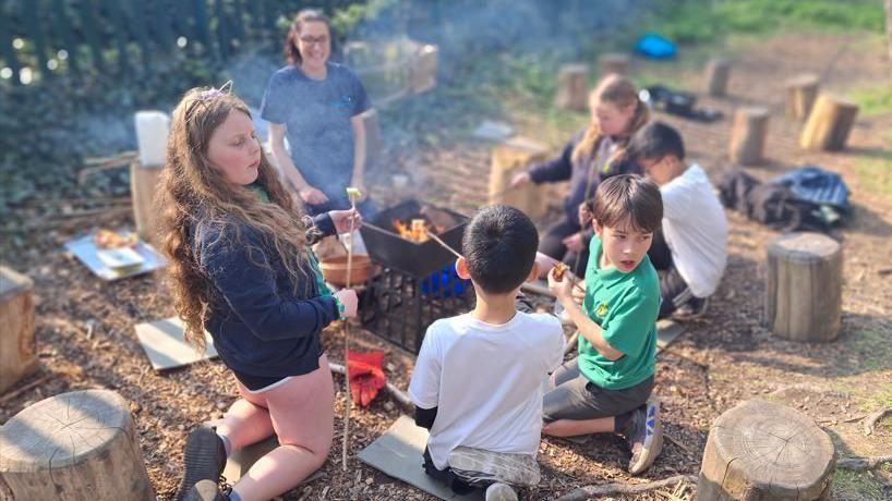 Plant gyda malws melys o flaen y tân