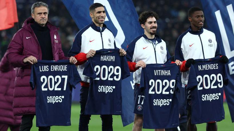 Luis Enrique, Achraf Hakimi, Vitinha and Nuno Mendes with shirts displaying dates to match their contract extension lengths