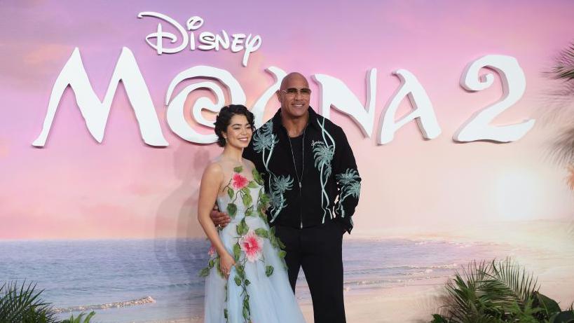 Auli'i Cravalho and Dwayne Johnson pose on the red carpet at the Moana 2 premiere in London. 