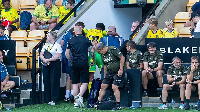 Ali Ahmed being helped off the pitch by the Norwich City medical team after suffering an injury