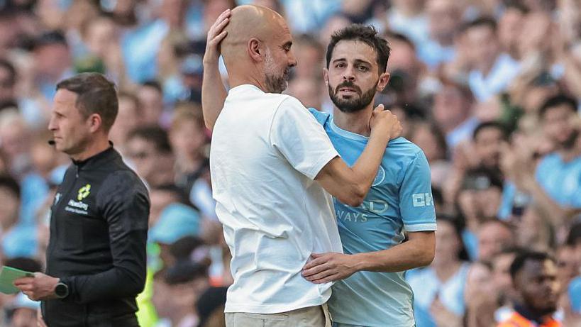 Pep Guardiola, manager of Manchester City, embraces Bernardo Silva