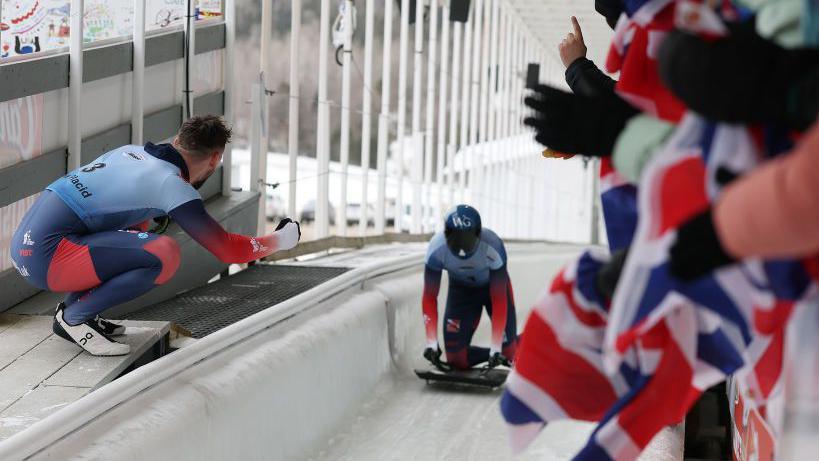 Marcus Wyatt (left) holds his fist out in celebration as Matt Weston comes into the finish on the track at the World Championships