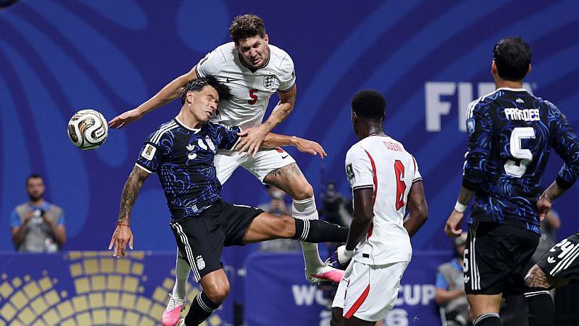 John Stones, leaping up, looks to win the ball in the air in England's match against Argentina