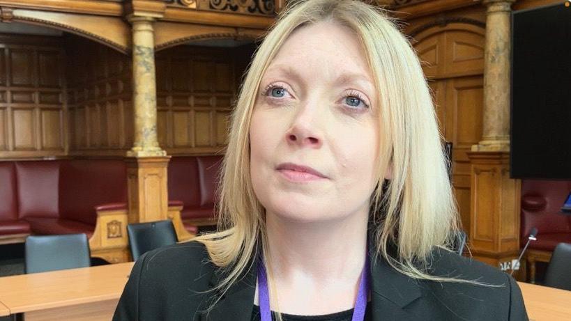 Picture of councillor Natalie Hoy. She is wearing a black suit jacket with a purple lanyard