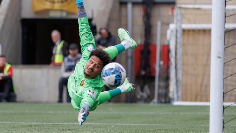 Shamal George diving to save the ball for Livingston