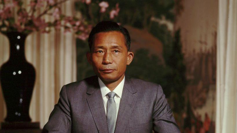 Park Chung-hee standing in front of a painting a flower vase