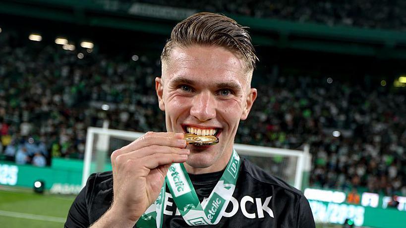 Viktor Gyokeres holds a medal between his teeth
