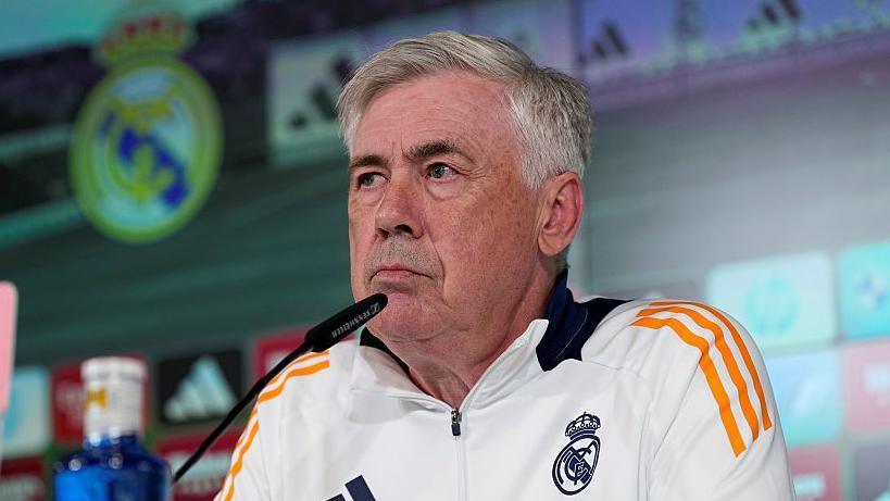 Carlo Ancelotti takes part in a press conference wearing a Real Madrid tracksuit top