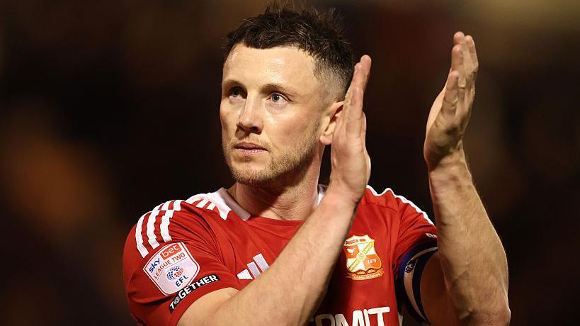 Swindon Town's Ollie Clarke applauds the fans