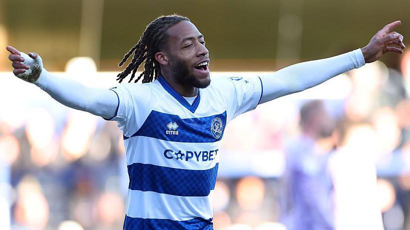 Rumarn Burrell celebrates after scoring for QPR with his arms outstretched and fingers pointing