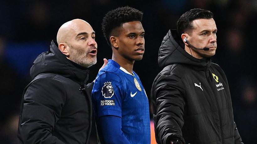 Chelsea winger Estevao Willian waiting to come on to the pitch as a substitute while standing next to manager Enzo Maresca