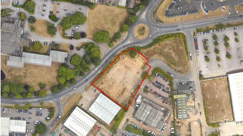 We can see an overhead satellite image centred on some derelict land. To the south are two large white buildings - those are the college.
