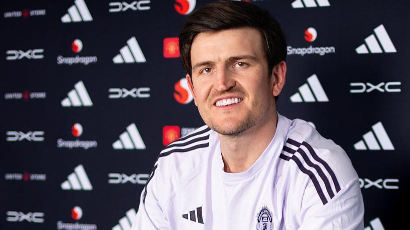 Harry Maguire smiling in a Manchester United news conference