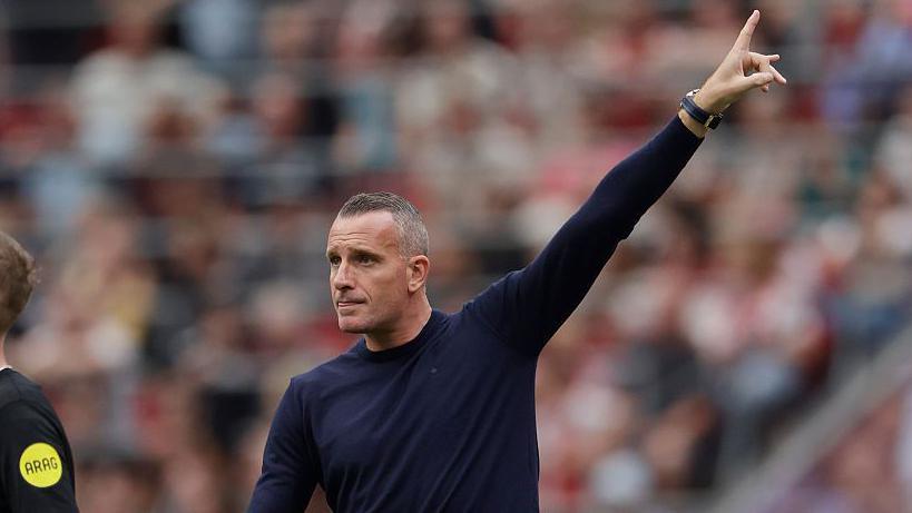 Nicky Hayen points to the sky during a pre-season game against Ajax