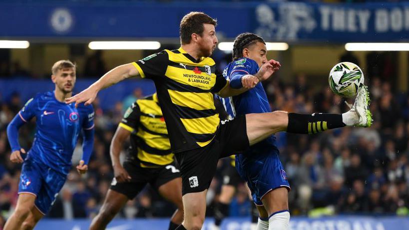 Chris Stokes battles for the ball against Chelsea