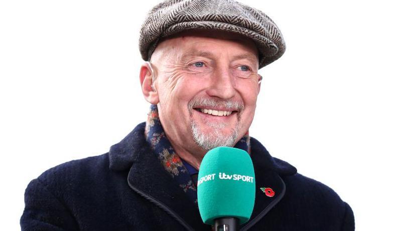 Ian Holloway holds a microphone