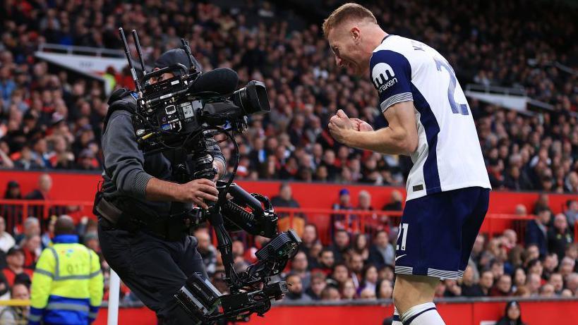 Tottenham's Dejan Kulusevski celebrates in front of a television camera