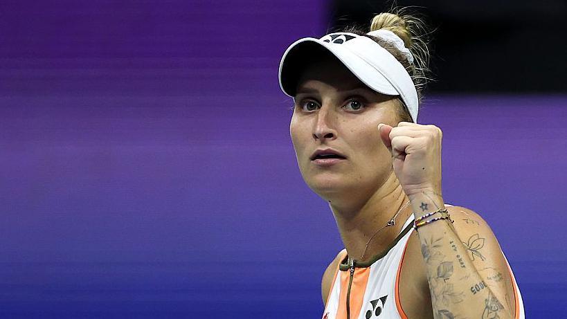 A woman, Marketa Vondrousova, raises a clenched left fist