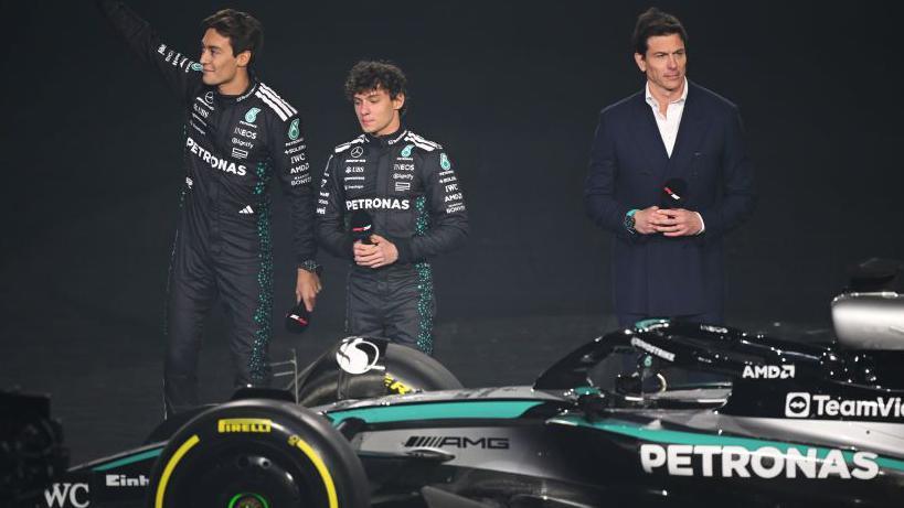 Mercedes drivers George Russell and Andrea Kimi Antonelli stood next to team boss Toto Wolff with a Mercedes F1 car in front of them