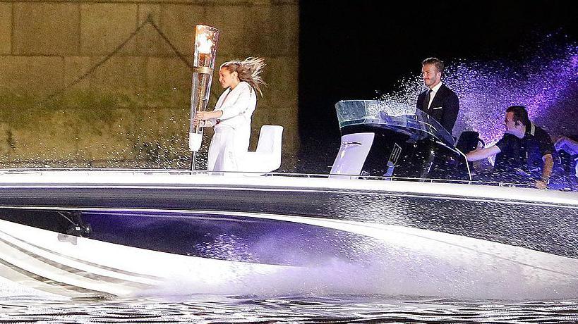 David Beckham drives a speedboat carrying the London 2012 Olympic torch to the opening ceremony