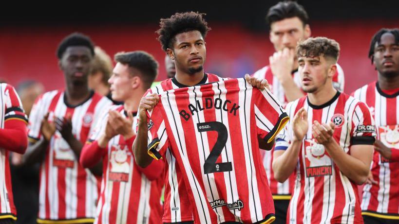 Rhian Brewster holds George Baldock's shirt aloft in tribute to his ex-teammate