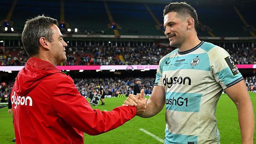 Bath director of rugby Johann Van Graan and Charlie Ewels shaking hands in celebration.