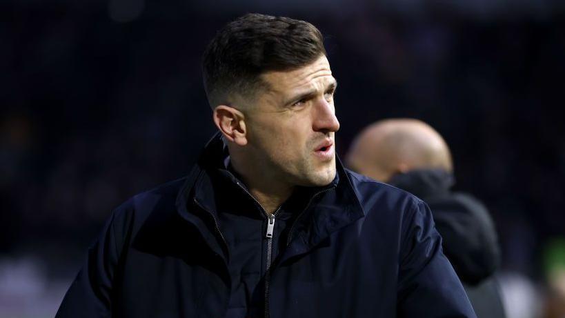 Portsmouth boss John Mousinho looks on from the touchline pre-match