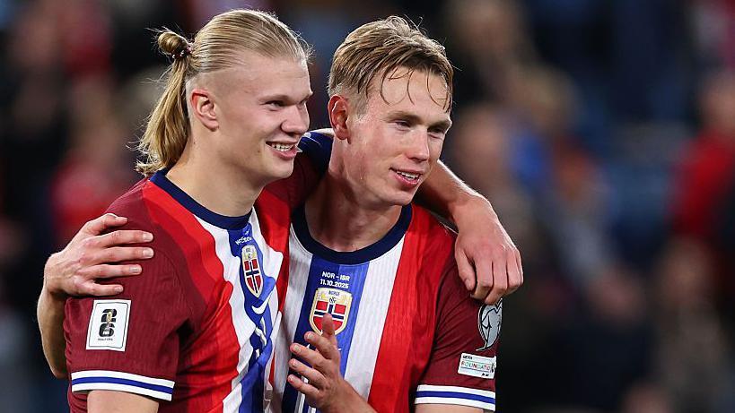 Picture of Erling Haaland and Torbjorn Heggem with their arms round each other after Norway celebrate a win.