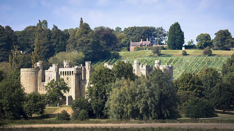 An image of Bodiam Castle, a 14th-century moated castle near Robertsbridge in East Sussex. Castle grounds can be seen in the backdrop of the image.