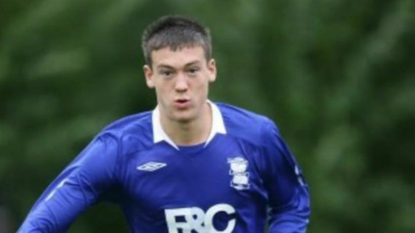 Jack Rutter in his younger years, running along a pitch in a long sleeved, blue football jersey with white writing and a white collar