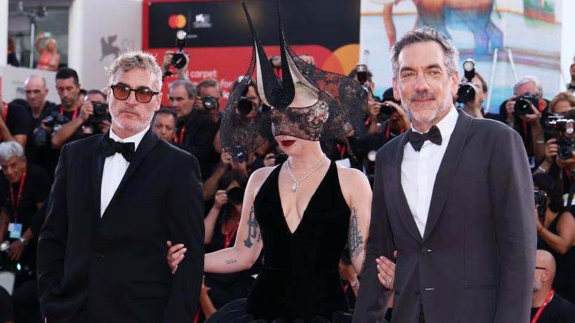 Joaquin Phoenix, Lady Gaga and director Todd Phillips at the Venice premiere with crowds of photographers on the red carpet