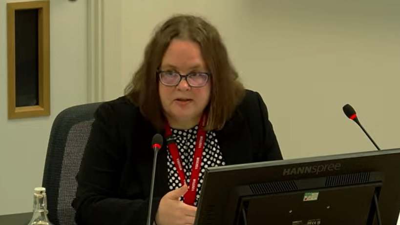 Dr Teresa Inkster sitting in front of a computer monitor, speaking into a microphone