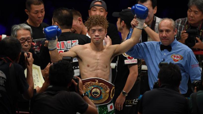Kosei Tanaka has his hand raised by the referee