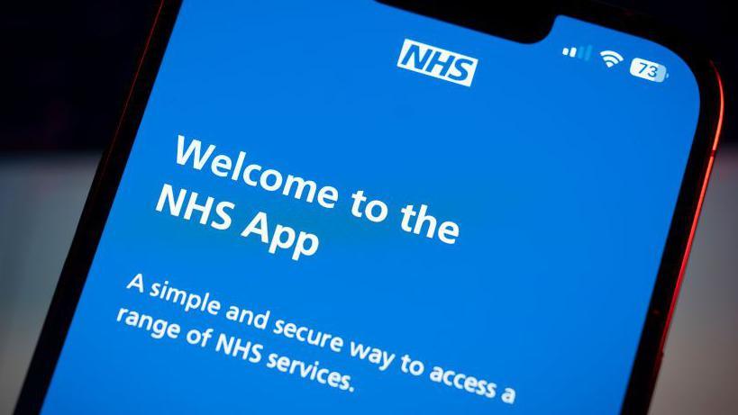 Close up phone screen, with Welcome to the NHS App in white on a blue background.  