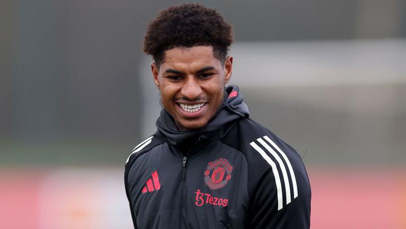Marcus Rashford smiles during training with Manchester United